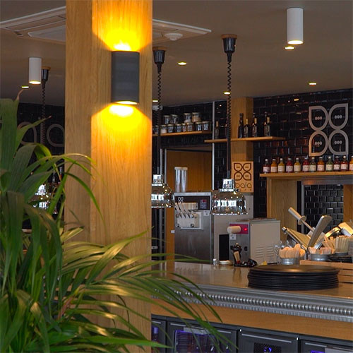 Une applique murale LED Luxna met en valeur toutes les parties bois du restaurant 